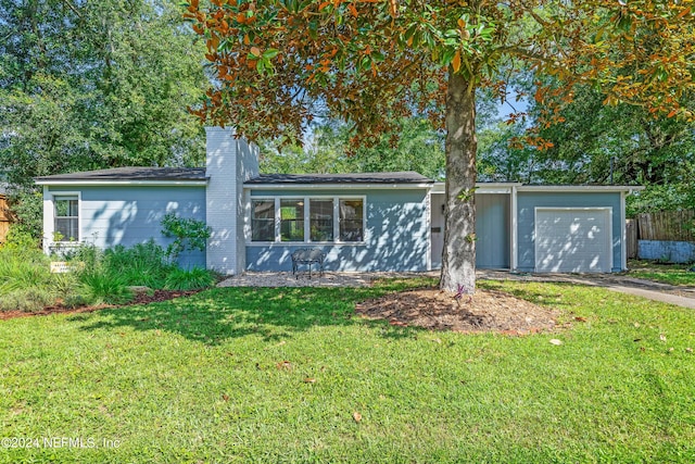 ranch-style house with a garage and a front lawn