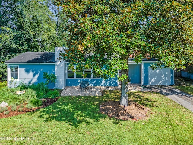 view of property hidden behind natural elements featuring a front yard