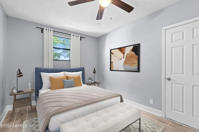 bedroom with a textured ceiling and ceiling fan