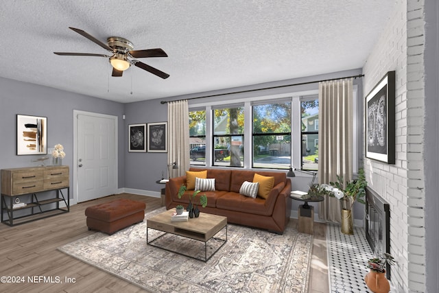 living room with a brick fireplace, hardwood / wood-style floors, and a textured ceiling