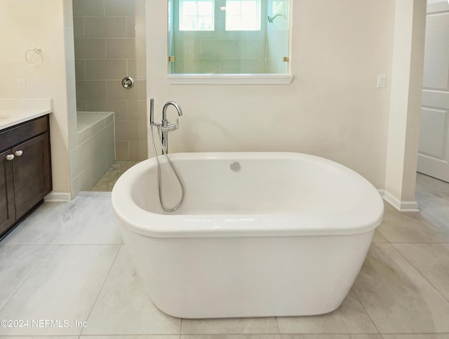 bathroom featuring a bathing tub, tile patterned flooring, and vanity