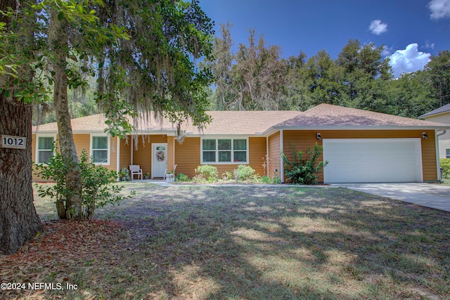 ranch-style home with a garage, concrete driveway, and a front lawn