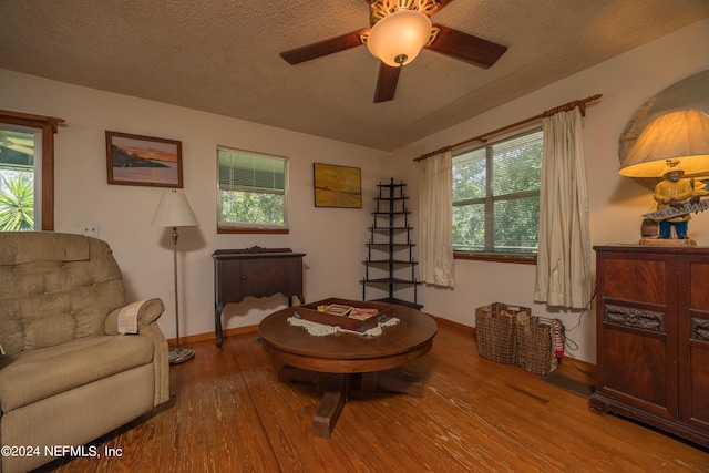 living area featuring ceiling fan, a textured ceiling, and light wood-type flooring