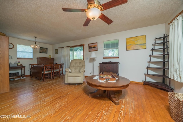 living room featuring hardwood / wood-style flooring, an inviting chandelier, and a textured ceiling