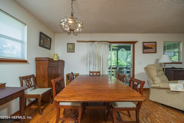 dining room featuring a chandelier, hardwood / wood-style floors, and a textured ceiling