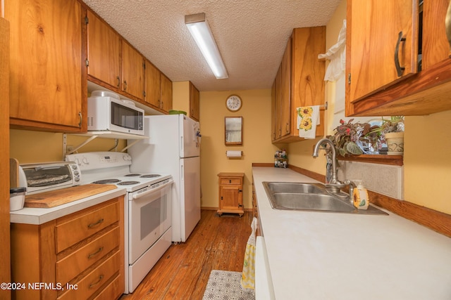 kitchen featuring sink, white electric range oven, a textured ceiling, and light hardwood / wood-style floors