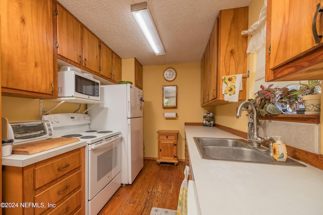 kitchen featuring electric stove, light hardwood / wood-style floors, sink, and a textured ceiling