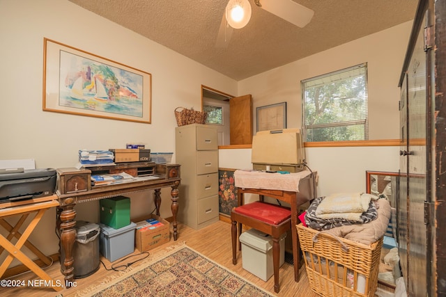 office space with ceiling fan, a textured ceiling, and light hardwood / wood-style floors