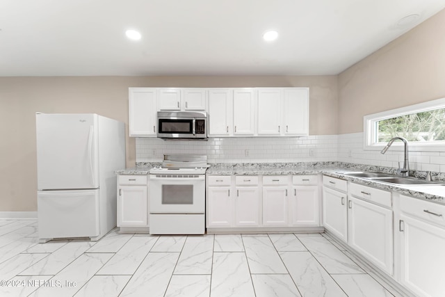 kitchen featuring sink, white appliances, and white cabinetry