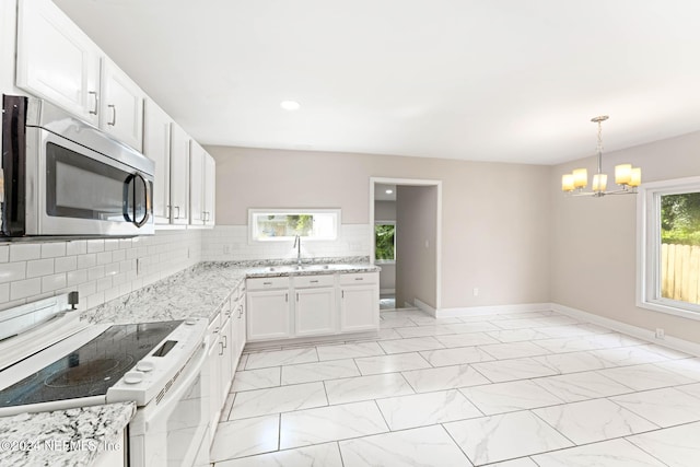 kitchen with pendant lighting, white electric range oven, tasteful backsplash, white cabinetry, and a notable chandelier