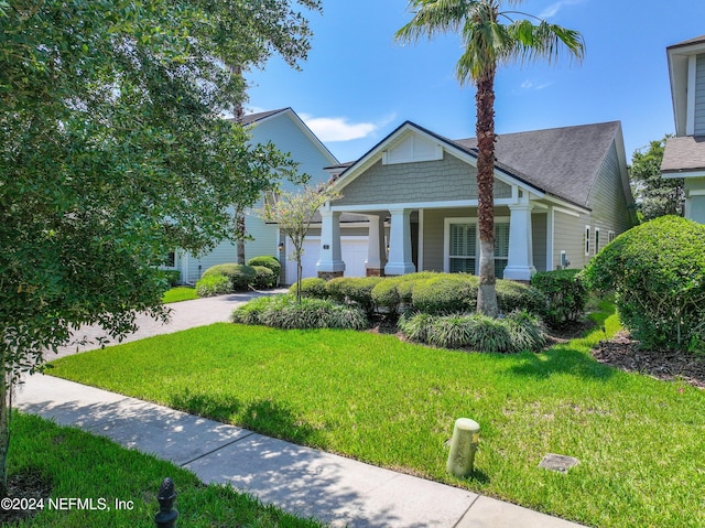 craftsman inspired home featuring decorative driveway, an attached garage, and a front lawn