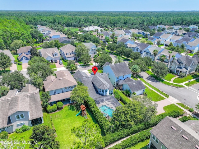 bird's eye view featuring a residential view and a wooded view