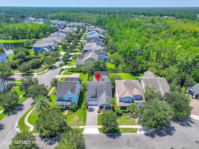 aerial view featuring a forest view, a water view, and a residential view