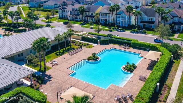 community pool with a residential view, fence, and a patio