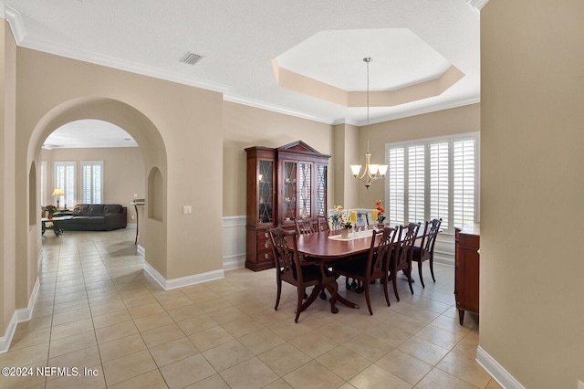 dining space featuring a chandelier, a tray ceiling, visible vents, and light tile patterned floors