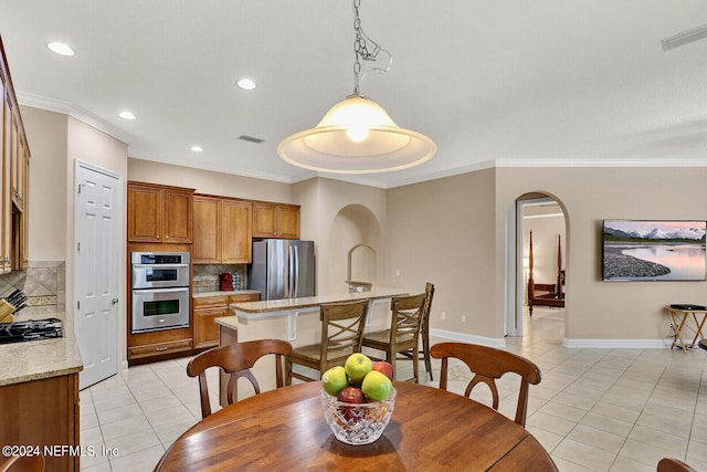 dining space with arched walkways, visible vents, crown molding, and light tile patterned floors