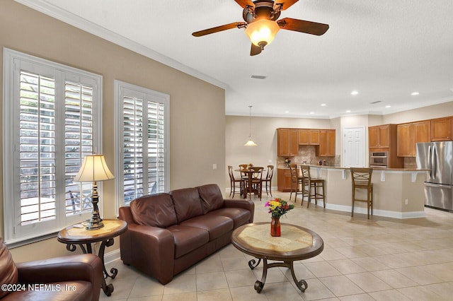 living room with light tile patterned floors, baseboards, visible vents, and a wealth of natural light