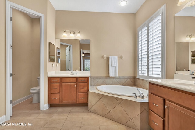 full bath featuring toilet, a garden tub, tile patterned flooring, and a sink