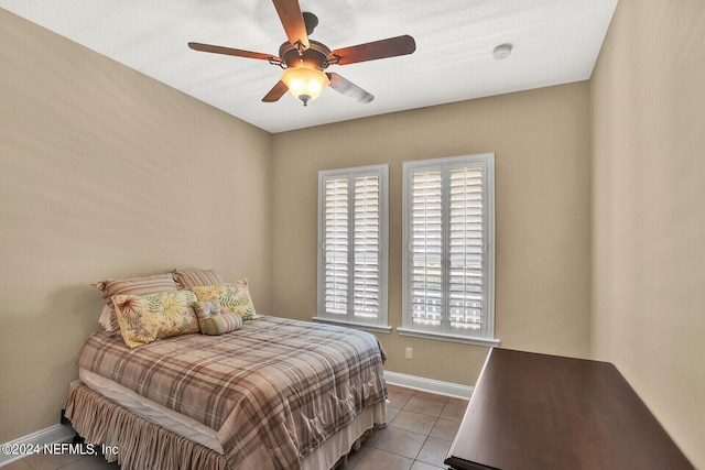 bedroom featuring a ceiling fan, baseboards, and light tile patterned floors