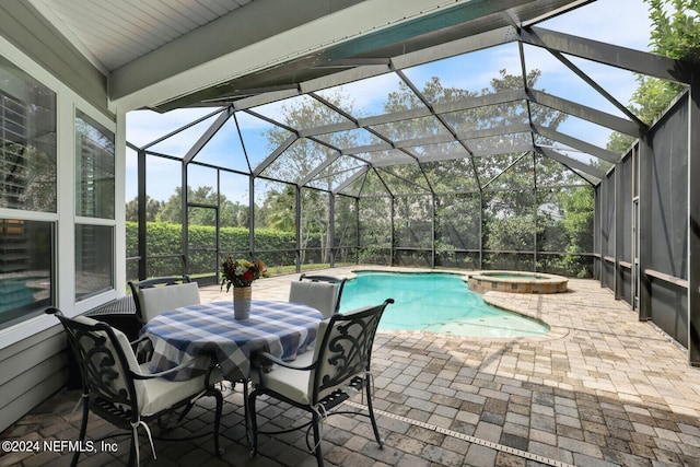 view of pool with a patio, glass enclosure, and a pool with connected hot tub