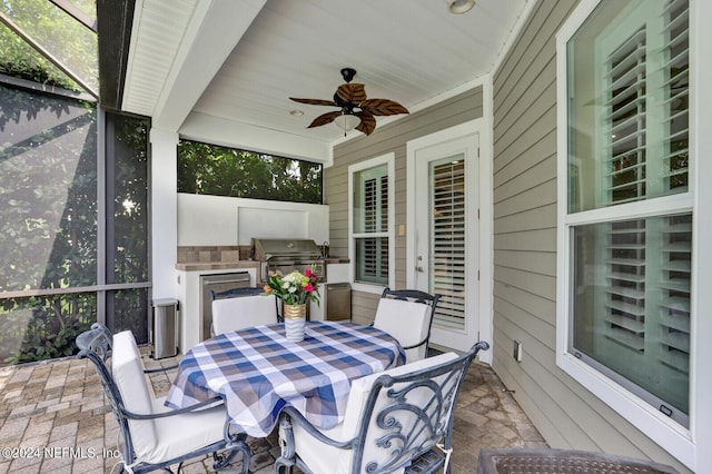 view of patio featuring ceiling fan, an outdoor kitchen, outdoor dining space, and area for grilling