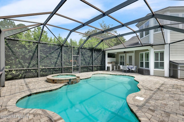 view of swimming pool with a patio area, a lanai, a pool with connected hot tub, and a ceiling fan