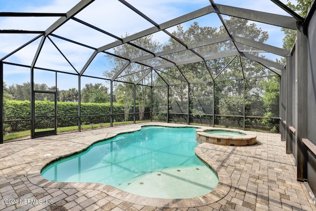 view of pool with a pool with connected hot tub, glass enclosure, and a patio