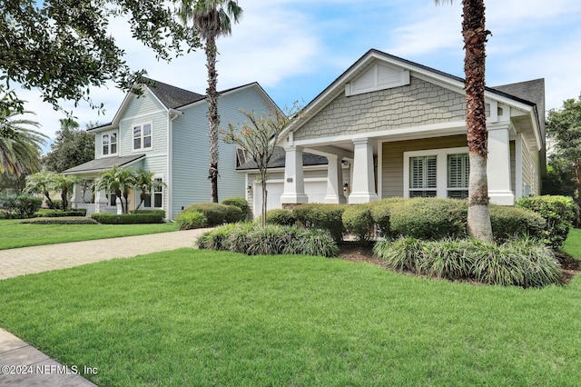 view of front of house with an attached garage and a front lawn