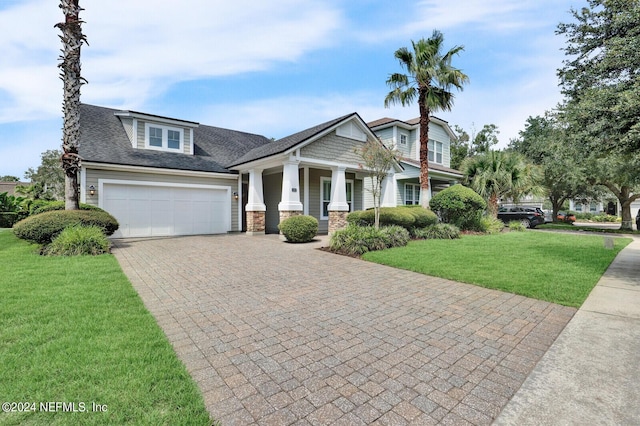 view of front of home featuring a garage, a front lawn, decorative driveway, and roof with shingles