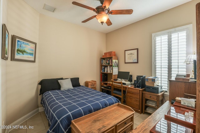 bedroom featuring light tile patterned floors, a ceiling fan, visible vents, and baseboards