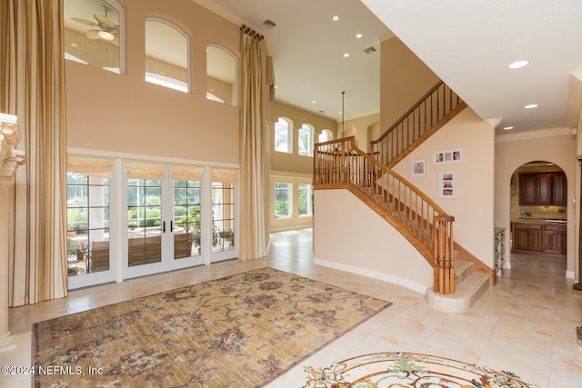 living room with arched walkways, recessed lighting, visible vents, stairway, and ornamental molding