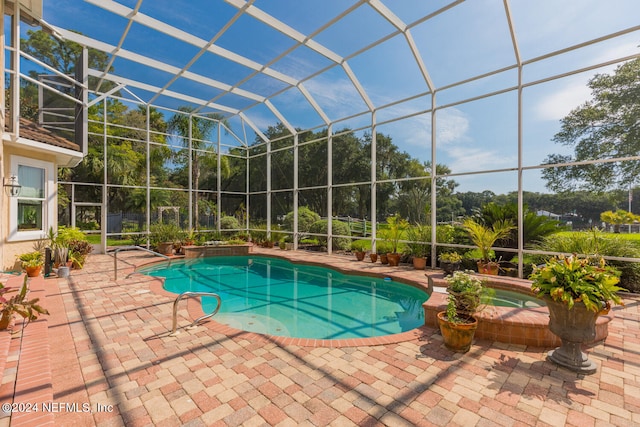 view of swimming pool featuring a lanai, a patio area, and a pool with connected hot tub