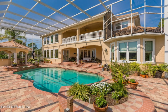 outdoor pool featuring a ceiling fan, french doors, a patio area, and a lanai