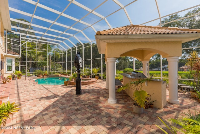 view of pool featuring a patio area, glass enclosure, a pool with connected hot tub, and area for grilling