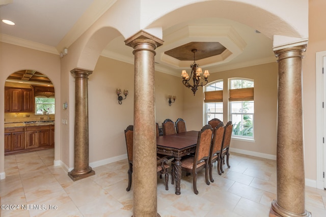 dining space with ornate columns, ornamental molding, a chandelier, coffered ceiling, and baseboards