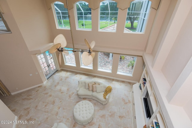 unfurnished living room featuring a high ceiling and baseboards