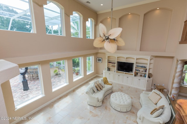 living area featuring baseboards, recessed lighting, a towering ceiling, and a ceiling fan