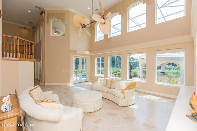 living room featuring a high ceiling, baseboards, crown molding, and french doors