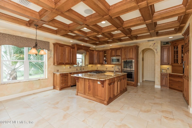 kitchen featuring brown cabinets, light stone counters, and stainless steel appliances