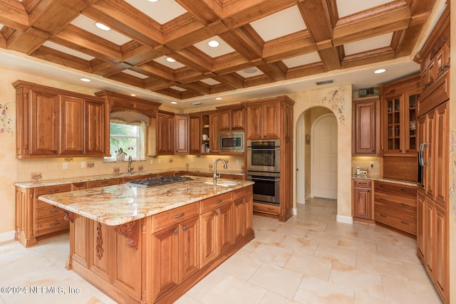 kitchen featuring arched walkways, appliances with stainless steel finishes, brown cabinets, light stone countertops, and a sink