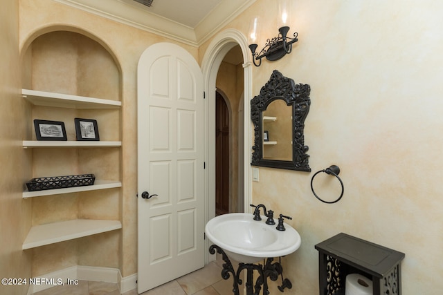 bathroom featuring crown molding, tile patterned floors, a sink, and built in features