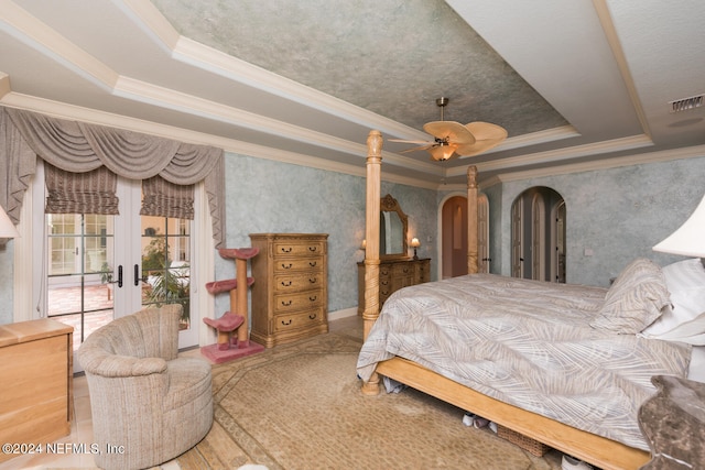 bedroom with visible vents, a raised ceiling, arched walkways, access to outside, and french doors