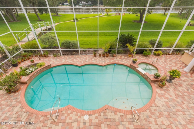 view of pool featuring glass enclosure, a patio, an in ground hot tub, a yard, and a fenced in pool