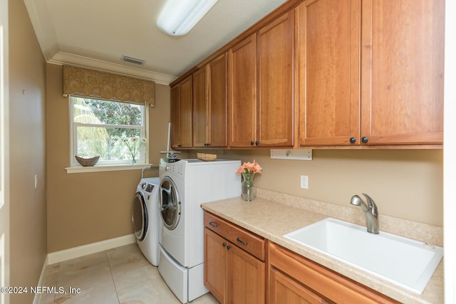 washroom with light tile patterned floors, a sink, visible vents, independent washer and dryer, and cabinet space