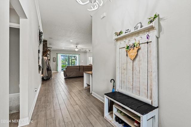 mudroom with ceiling fan, light hardwood / wood-style floors, and a textured ceiling