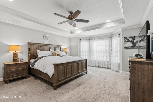 carpeted bedroom with crown molding, ceiling fan, a raised ceiling, and a textured ceiling