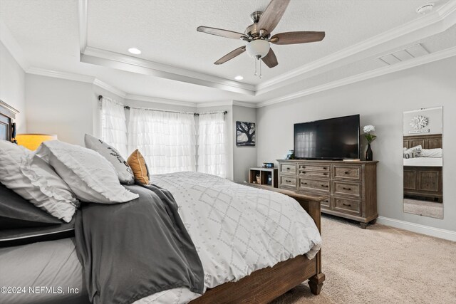 carpeted bedroom featuring ornamental molding, a raised ceiling, and ceiling fan