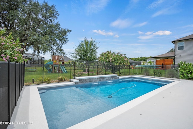 view of pool with pool water feature, a yard, a lanai, and a playground