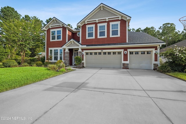 craftsman inspired home with a garage and a front lawn