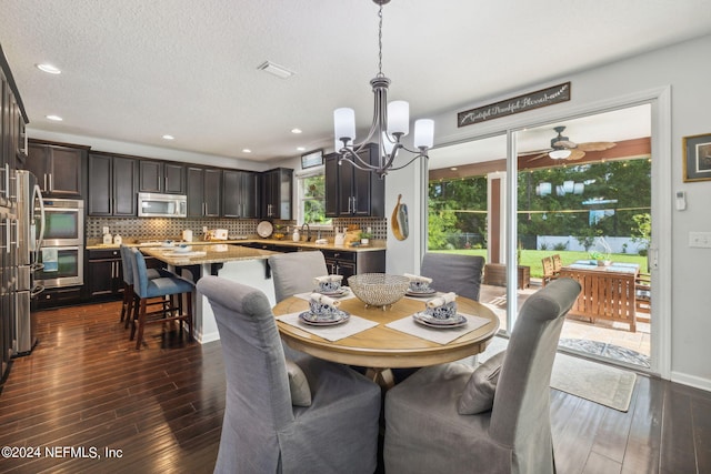 dining area with an inviting chandelier, sink, and dark wood-type flooring